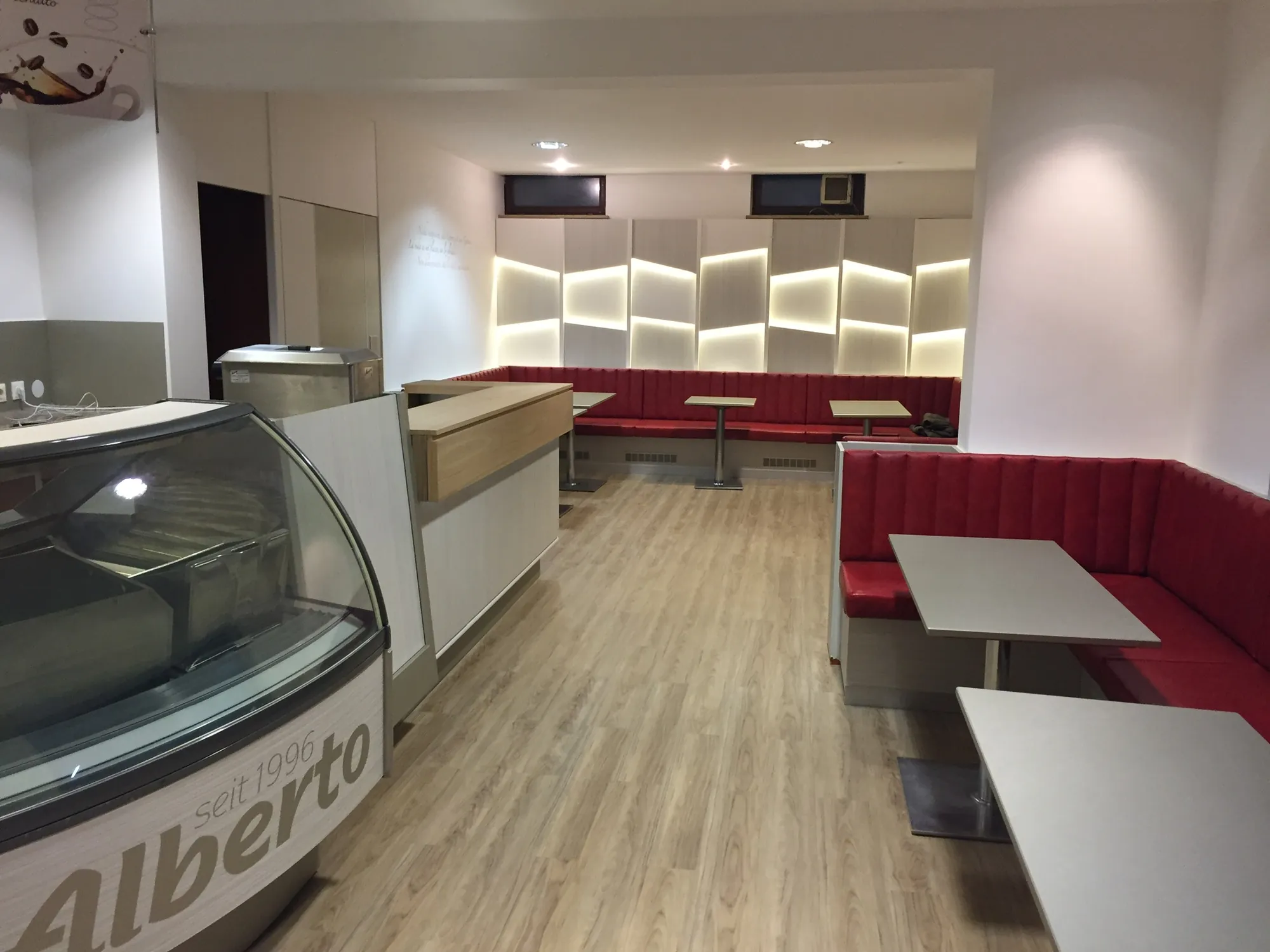 La sala rinnovata dell’Eis Café Alberto con la vetrina, le panche rosse e la parete retroilluminata
