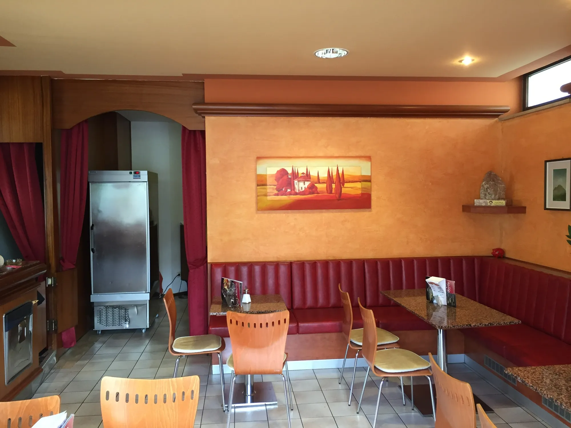 La sala dell’Eis Café Alberto prima del restyling, con pareti aranciate e panche rosse