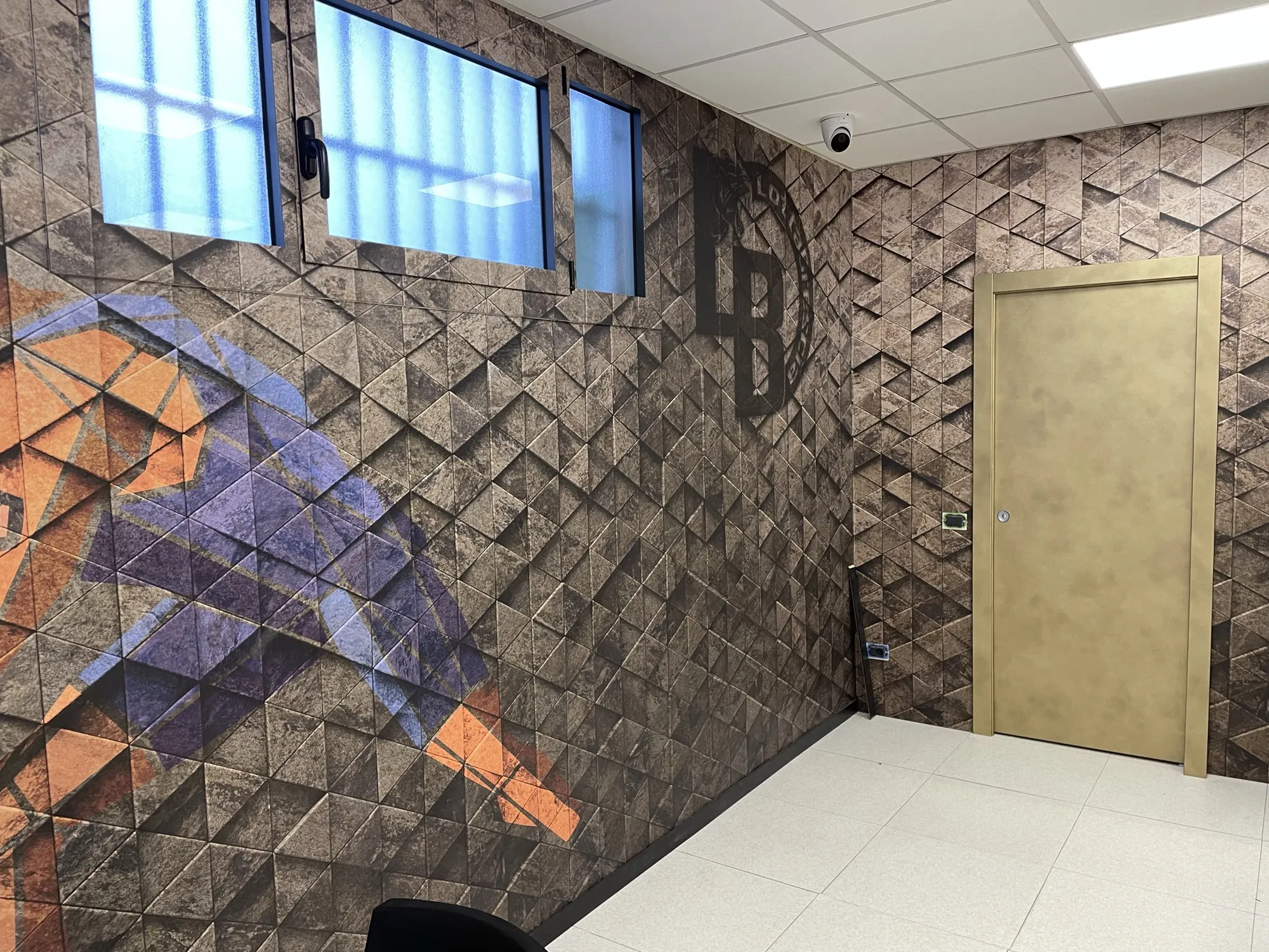 Dettaglio della parete grafica con la porta rivestita in oro