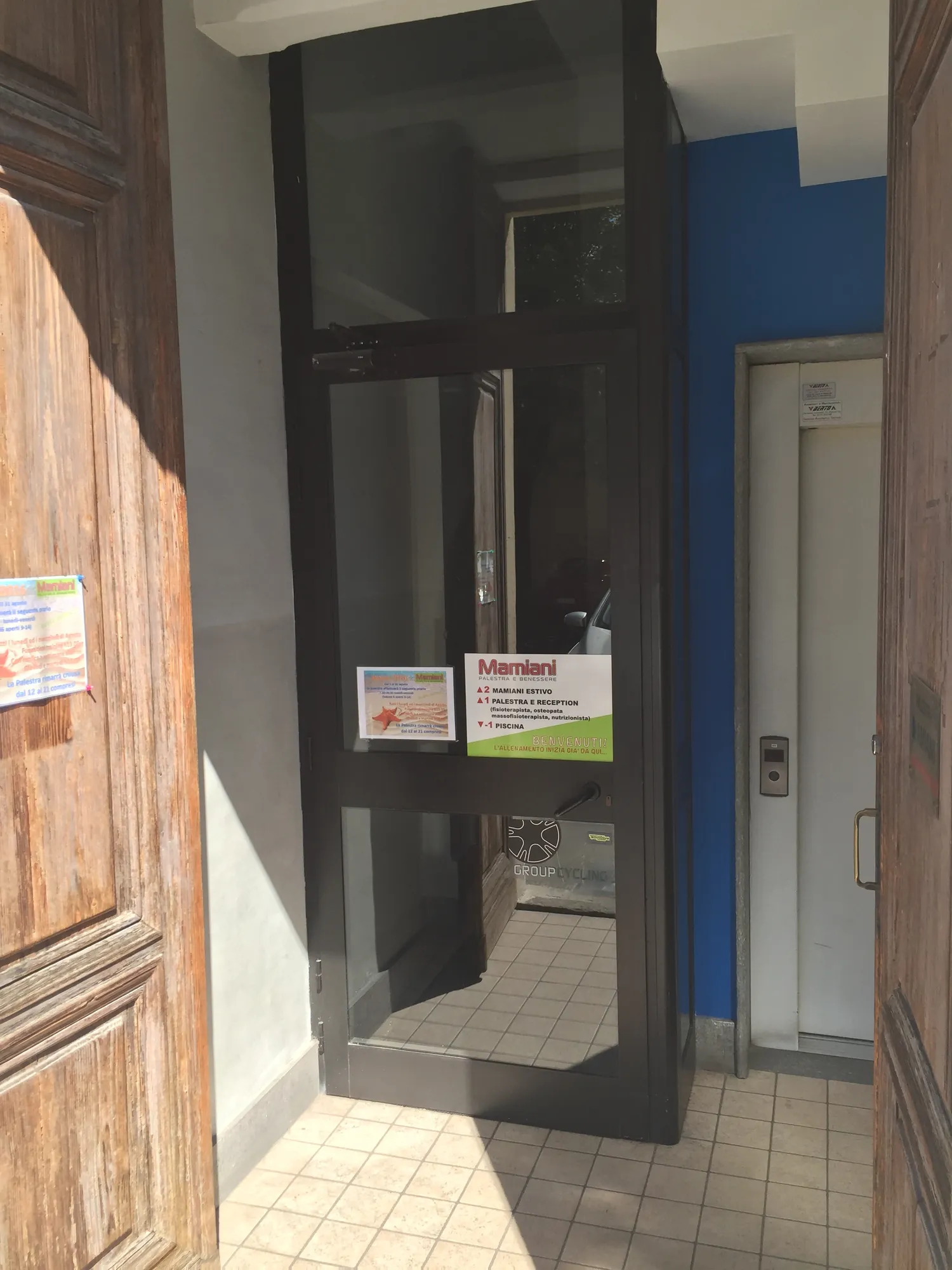La porta interna d’ingresso in vetro e metallo, prima dell’intervento