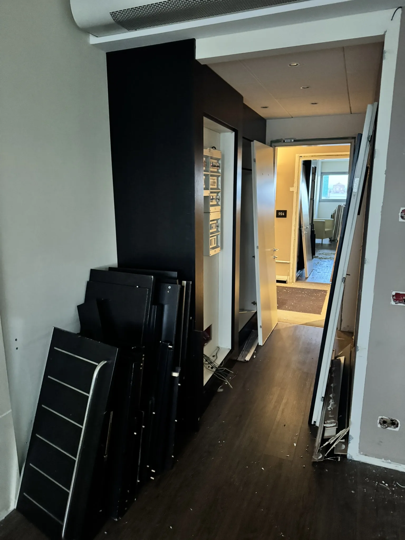 Wardrobe doors and panels dismantled and being worked on in the corridor